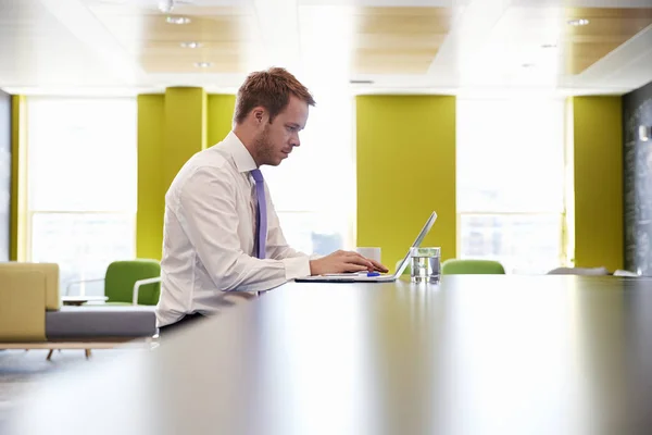 Homme d'affaires utilisant un ordinateur portable dans une zone de réunion de bureau — Photo