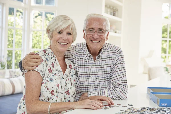 Senior Paar Een Puzzel Thuis Lacht Camera Doen — Stockfoto