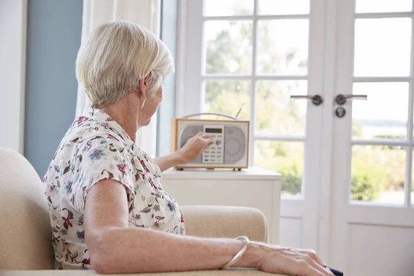 家でラジオを聞いて肘掛け椅子で年配の女性 — ストック写真