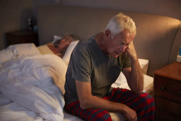 Martwi się starszy człowiek w łóżku — Zdjęcie stockowe