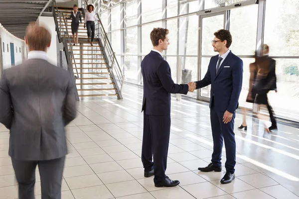 Dos hombres de negocios blancos estrechando las manos — Foto de Stock