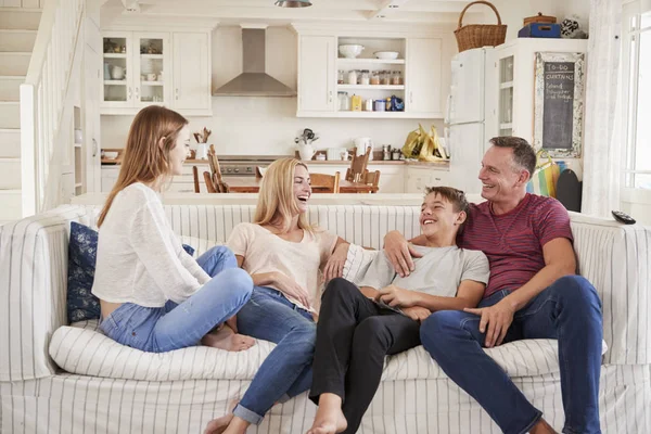 Семья с детьми-подростками отдыхает на диване — стоковое фото