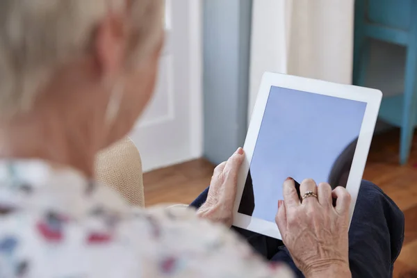 Senior Kobieta Przy Użyciu Komputera Typu Tablet Przez Ramię Widok — Zdjęcie stockowe