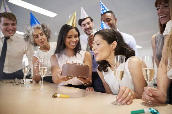 Woman blows out candles on birthday cake — Stock Photo, Image