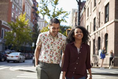 Young Couple Walking Along Urban Street In New York City clipart