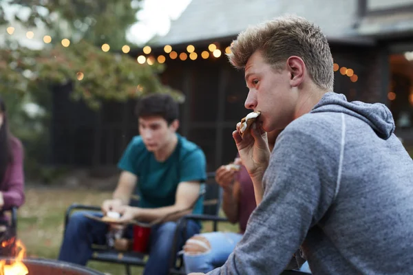 Εφηβικό Αγόρι Τρώει Smore Των Φίλους Ένα Κοίλωμα Πυρκαγιάς — Φωτογραφία Αρχείου