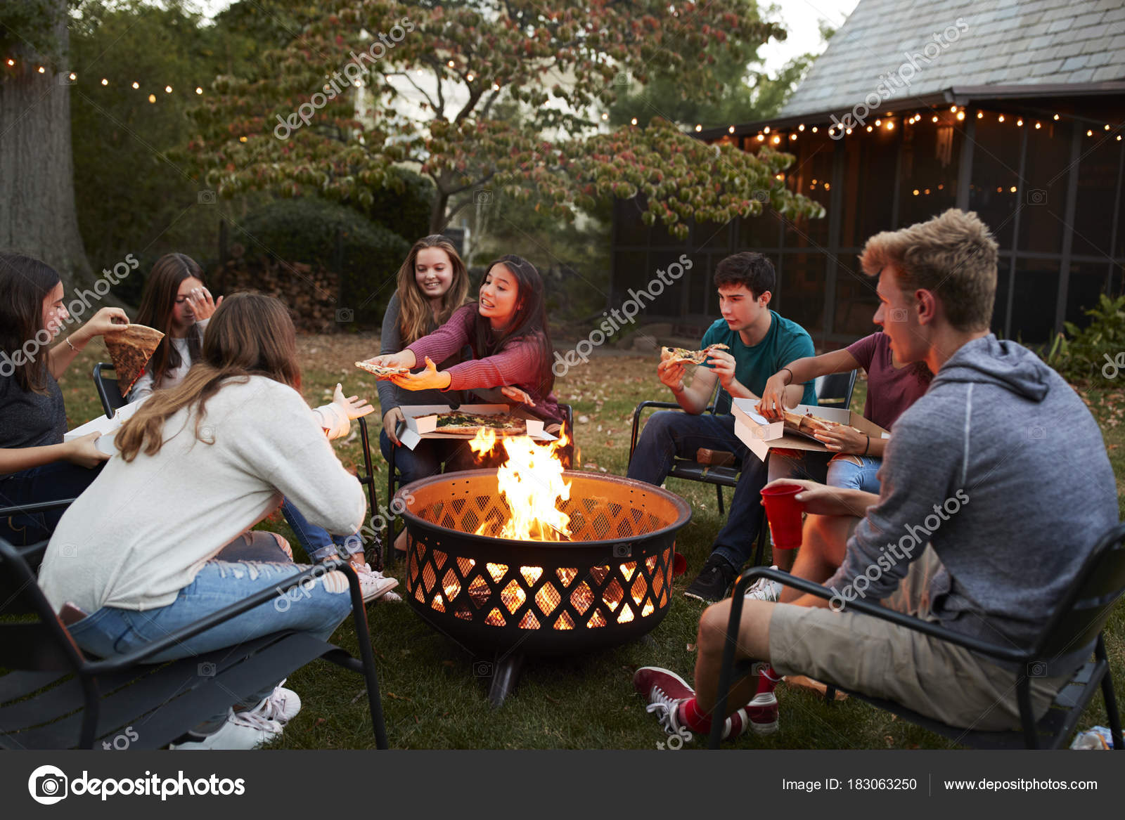 Teenage Friends Sit Fire Pit Eating, Sitting Around Fire Pit