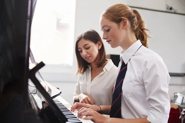 音楽のレッスンでピアノを弾く先生と女子生徒 — ストック写真