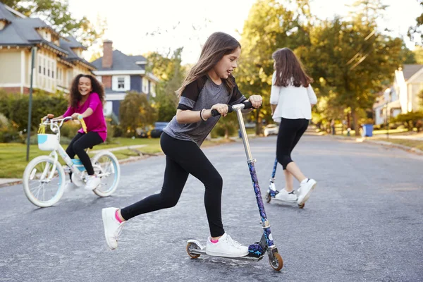 Meninas Brincando Rua Scooters Uma Bicicleta Close — Fotografia de Stock