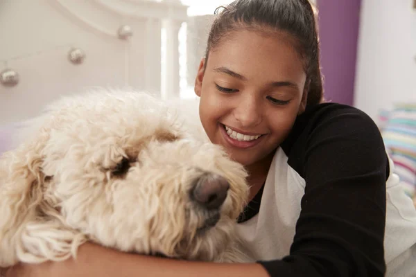 彼女のベッドの上のペットの犬を受け入れる若い十代の少女をクローズ アップ — ストック写真