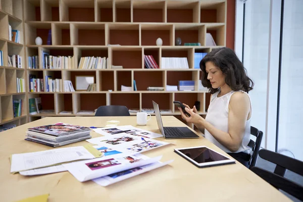 그녀의 책상에서 스마트폰을 창조적인 미디어 사무실에서 — 스톡 사진