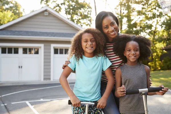 Madre Con Niños Montando Scooters Camino Entrada Casa — Foto de Stock