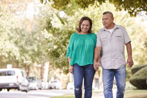 Pareja Mayor Caminando Largo Calle Suburbana Sosteniendo Las Manos —  Fotos de Stock