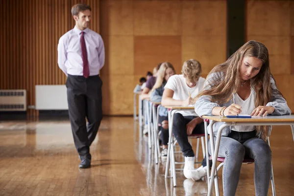 Teenage Studenti Sedí Vyšetření Učitelem Invigilating — Stock fotografie