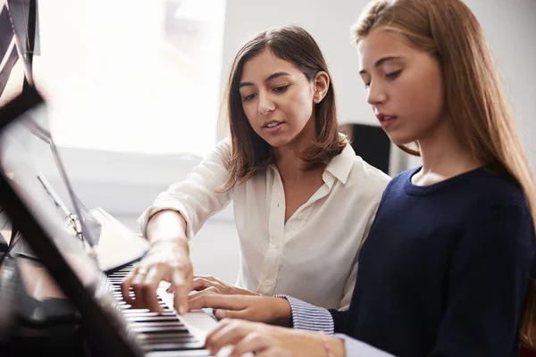 Criança a tocar piano. Lição de música online com professor por