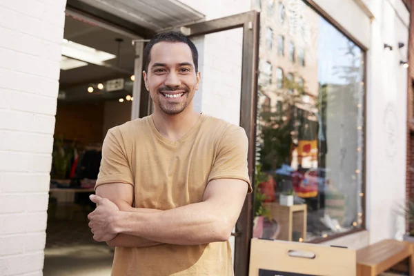 年轻的拉美裔店主微笑着在他的店外的摄像头 — 图库照片