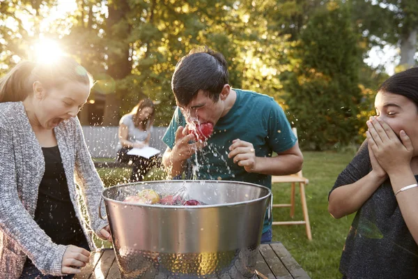 Freunde Beobachten Teenager Bei Gartenparty Beim Apfelwippen — Stockfoto