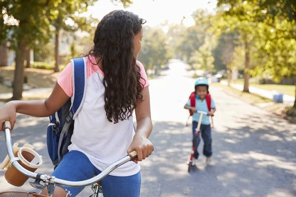 Søster Med Bror Ridning Scooter Cykel Til Skole - Stock-foto