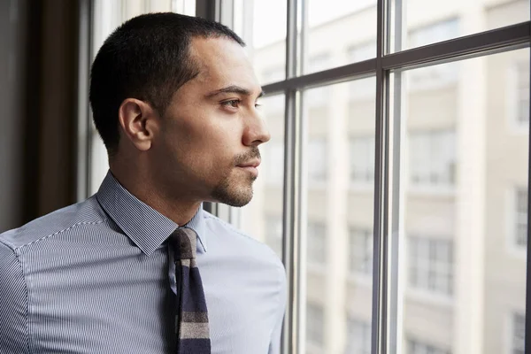 Ung Hispanic Business Man Ser Fönster — Stockfoto