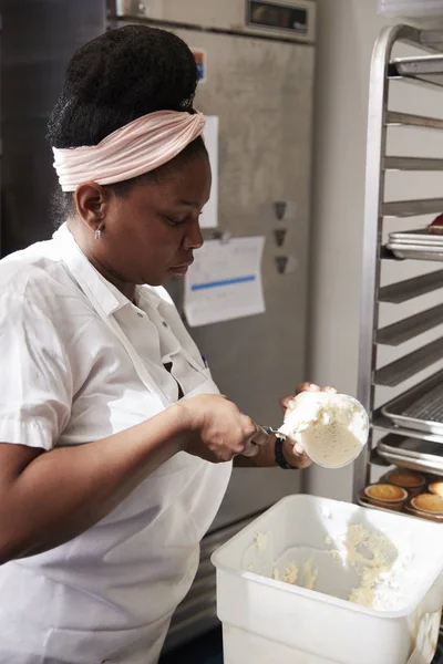 若い黒ケーキ フロスティングを準備するパン屋の女性 — ストック写真