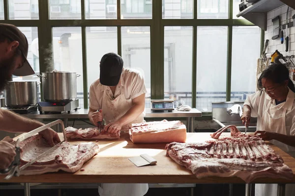 Tres Carniceros Preparando Cerdo Una Carnicería —  Fotos de Stock