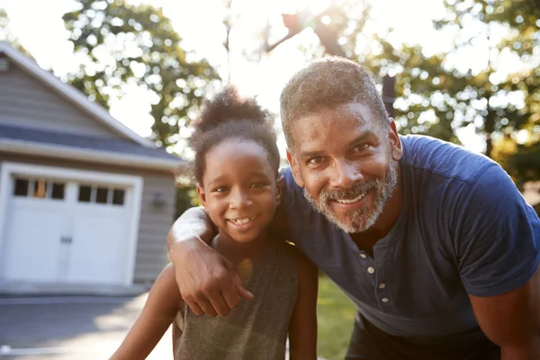 Portrait Of Father And Son Playing Basketball On Driveway