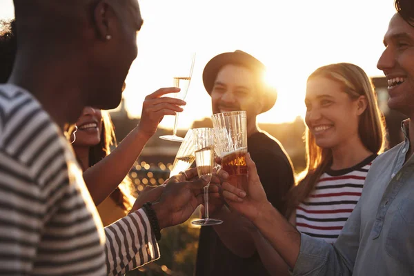 Friends making a toast at a rooftop party, close up