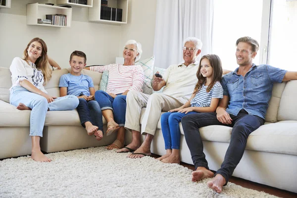 自宅でテレビを見てソファに座って多世代家族 — ストック写真
