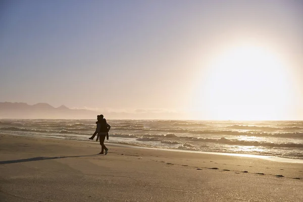 Silhouette ของพ อให กชาย Piggyback บนชายหาดฤด หนาว — ภาพถ่ายสต็อก