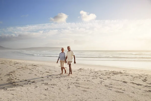 资深退休夫妇一起漫步海滩携手共进 — 图库照片