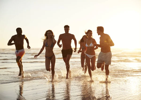 Grupa Przyjaciół Biegają Przez Fale Razem Wakacjach Plaży — Zdjęcie stockowe