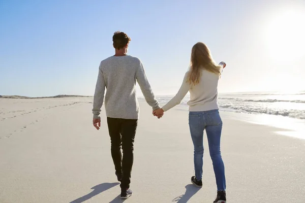 冬の浜辺に沿って一緒に歩くカップルを愛するの背面図 — ストック写真