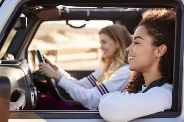 两位年轻女性朋友在阳光下开车 侧面看 — 图库照片