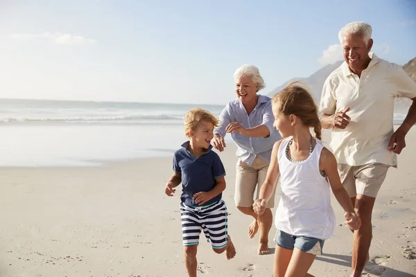 Nagyszülők Futás Unokái Strand Mentén Nyaralás — Stock Fotó