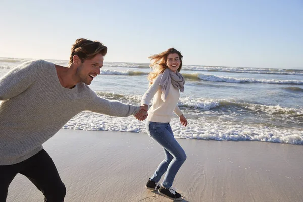 Pareja Divirtiéndose Corriendo Largo Invierno Playa Juntos —  Fotos de Stock