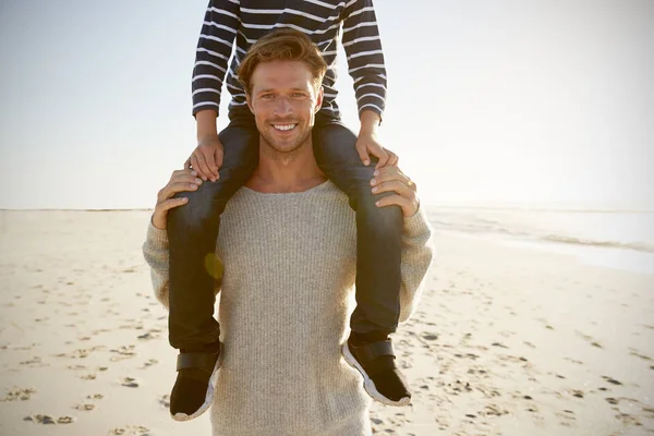 冬のビーチでの肩の上の息子を運ぶ父の詳細 — ストック写真