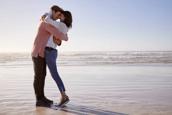浪漫情侣一起沿着冬季海滩漫步 — 图库照片