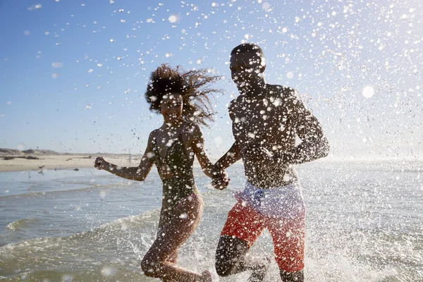 Pareja Divirtiéndose Corriendo Través Olas Vacaciones Playa — Foto de Stock