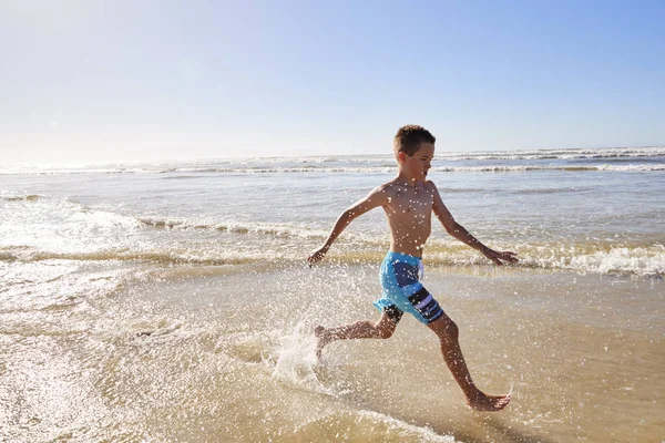 夏休みの波を介して実行している少年 — ストック写真