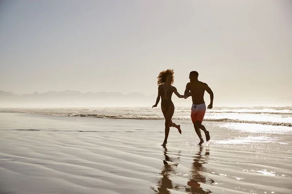 Pareja Divirtiéndose Corriendo Través Olas Vacaciones Playa — Foto de Stock