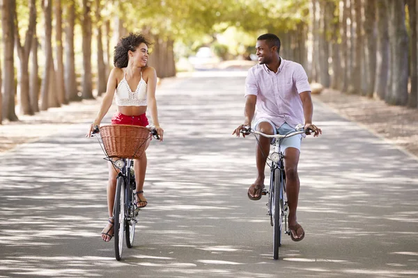 Jovem Casal Misto Andar Bicicleta Olhando Para Outro — Fotografia de Stock