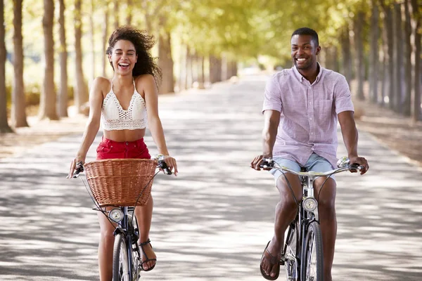 Pareja Joven Raza Mixta Montando Bicicletas Camino Arbolado —  Fotos de Stock