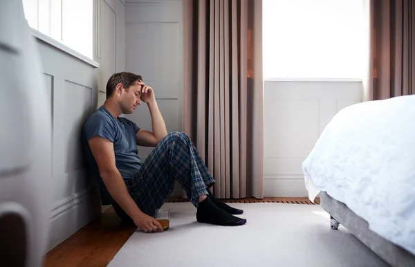 Depressed Man Wearing Pajamas Sitting Floor Bedroom Holding Glass Whisky — Stok Foto