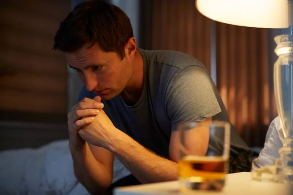 Depresivní Muž Pyžamu Sedí Boku Postele Sklenicí Whisky Nočním Stolku — Stock fotografie