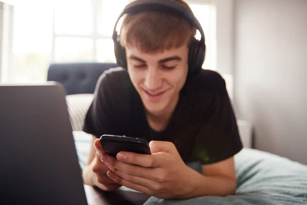 Estudiante Universitario Masculino Que Usa Auriculares Acuesta Cama Casa Compartida —  Fotos de Stock