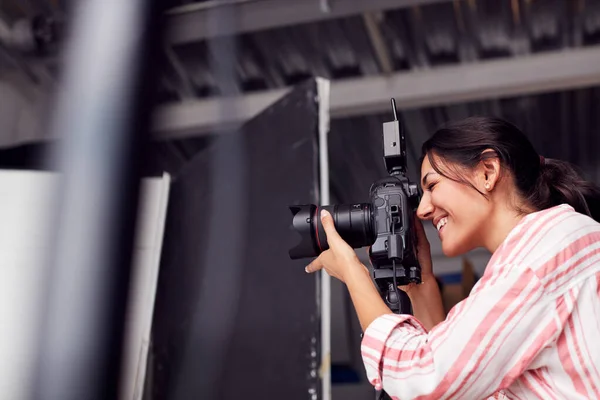 Kobieta fotograf z aparatem fotograficznym na sesji zdjęciowej przeciwko białej Stu — Zdjęcie stockowe