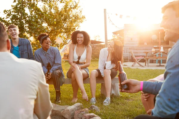 外でビールを飲みながら座っている音楽祭の若者のグループ — ストック写真