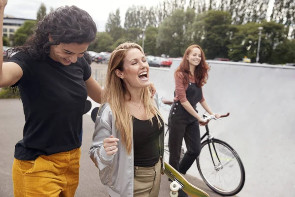 滑板和自行车穿越城市滑板公园的女性朋友 — 图库照片