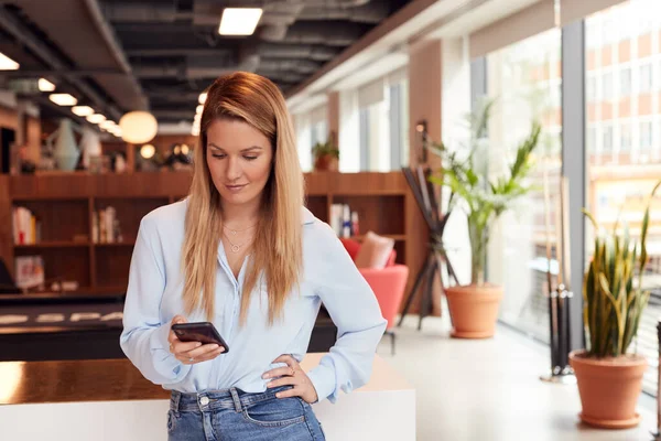 Casualmente Vestida Joven Empresaria Chequeando Teléfono Móvil Lugar Trabajo Moderno — Foto de Stock