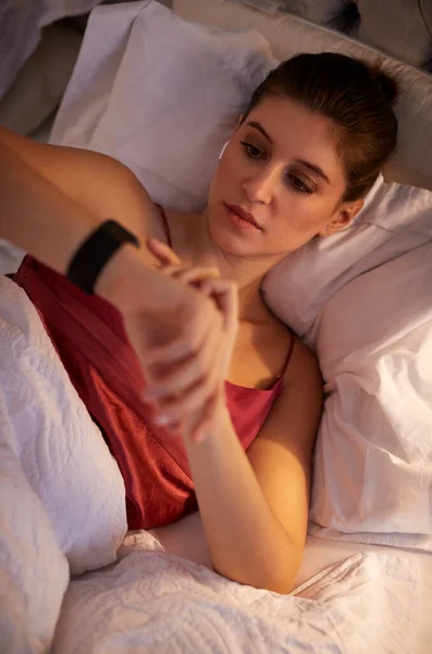 Γυναίκα Ξαπλωμένη Στο Κρεβάτι Ελέγχοντας Έξυπνο Ρολόι Πριν Πάει Για — Φωτογραφία Αρχείου
